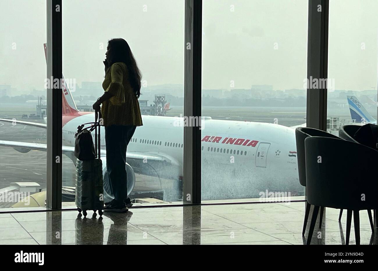 La donna attende il volo all'aeroporto di Mumbai Foto Stock
