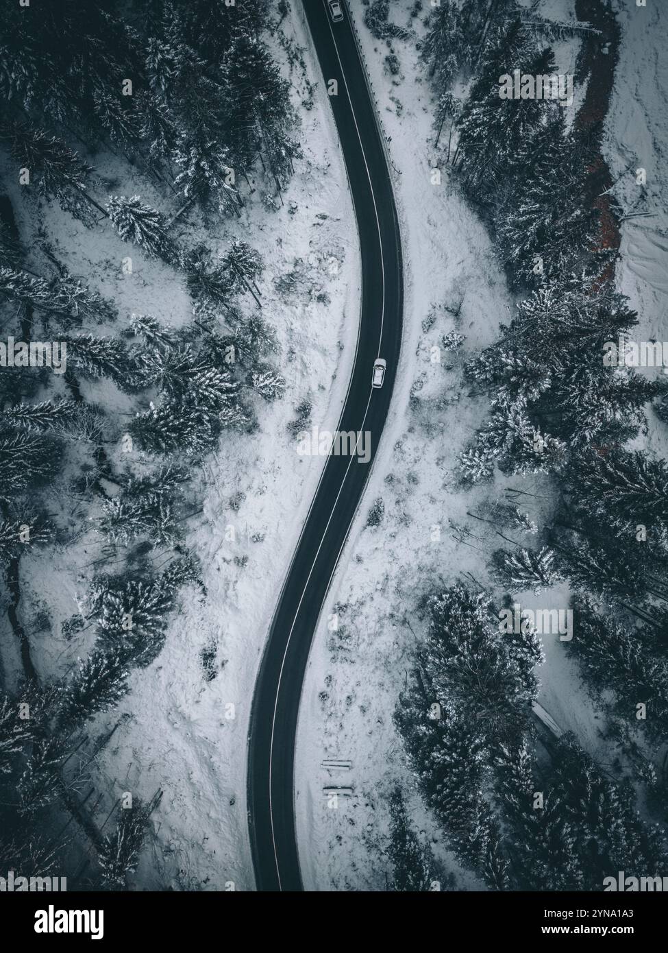 Vista aerea di una strada in una foresta innevata Foto Stock