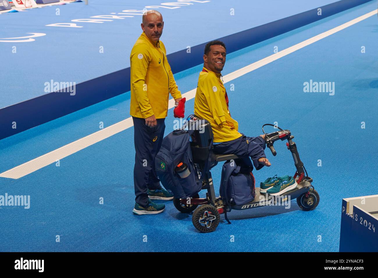 Francia, Hauts de Seine, la Defense, la Defense Arena piscina installata esclusivamente per i Giochi Olimpici e Paralimpici di Parigi 2024, gare di nuoto para, il nuotatore brasiliano Gabriel dos Santos Araujo dopo aver ricevuto la medaglia d'oro nei 100 m dorso nella categoria S2 con il suo allenatore Foto Stock