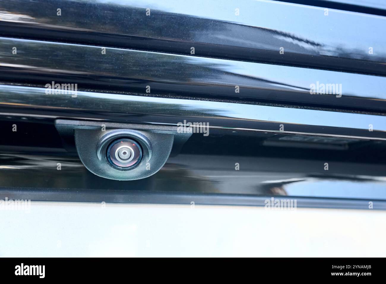 Telecamera per la visione posteriore dell'auto, sensore di parcheggio, accessorio retromarcia, nuova Spycam del veicolo con gocce d'acqua. Primo piano della telecamera posteriore di un'auto di lusso per il parcheggio automatico Foto Stock