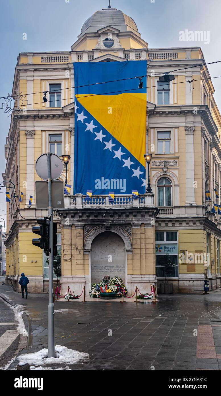 Bandiera bosniaca e ghirlande intorno a fiamma eterna per statualità giorno Foto Stock