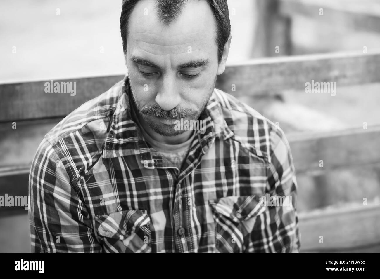 Uomo di mezza età con capelli facciali, con camicia a quadri in bianco e nero Foto Stock