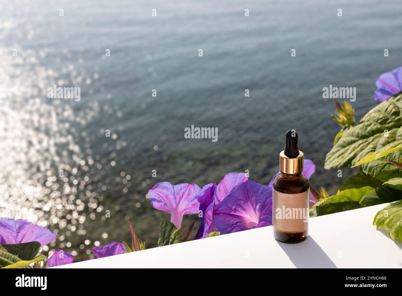 Flacone per siero con oceano e fiori sullo sfondo Foto Stock