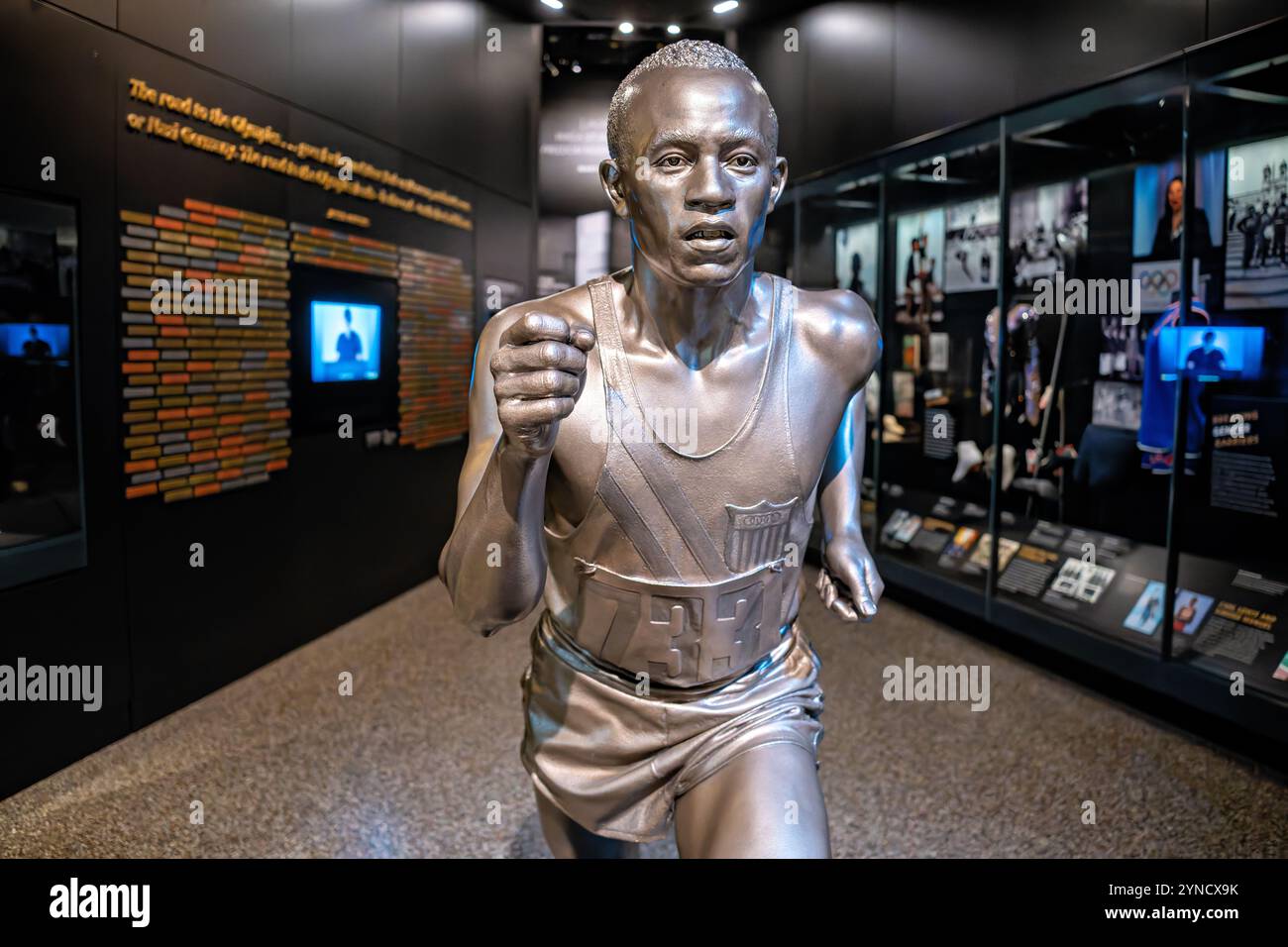 Jesse Owens Statue National Museum Washington DC // WASHINGTON DC — Una statua di Jesse Owens in pieno ritmo commemora il suo storico successo di vincere quattro medaglie d'oro alle Olimpiadi del 1936, esposta nella mostra Sports: Leading the Playing Field al National Museum of African American History and Culture. La mostra esplora l'intersezione tra atletica e attivismo nella storia afroamericana. Foto Stock
