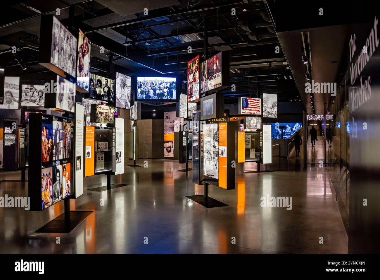 National Museum of African American History and Culture Exhibition Washington DC | WASHINGTON D.C., Stati Uniti - schermi a parete e pannelli fotografici riempiono la galleria "A Changing America: 1968 and Beyond" del National Museum of African American History and Culture, che ripercorre la vita politica e culturale afroamericana dall'assassinio di Martin Luther King Jr. Un visitatore cammina lungo il corridoio passando per immagini d'archivio che spaziano dall'era del Black Power ai movimenti contemporanei. Foto Stock