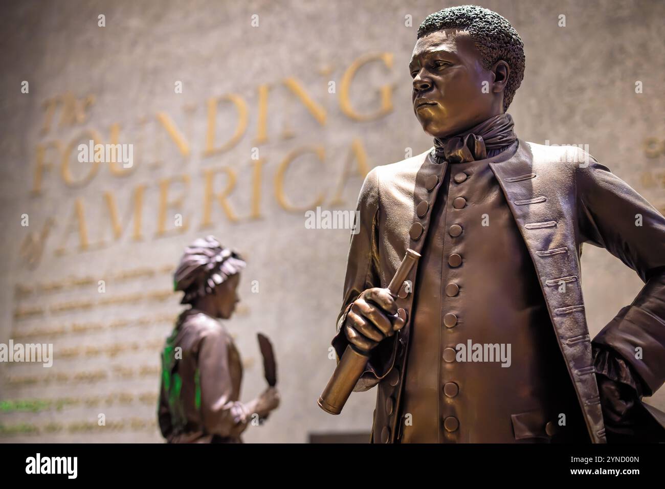 Statua di Benjamin Banneker African American Museum Washington DC // WASHINGTON DC — il National Museum of African American History and Culture mette in mostra Benjamin Banneker, un matematico, scienziato e autore almanacco autodidatta del XVIII secolo. Nato libero nel Maryland nel 1731, Banneker superò le barriere sociali per diventare un notevole inventore, geometra e abolizionista. I suoi successi, tra cui la costruzione di orologi in legno e la partecipazione al sondaggio sulla terra del Distretto di Columbia, dimostrarono le capacità intellettuali afroamericane durante un'era di razzismo e schiavitù diffusi. Foto Stock