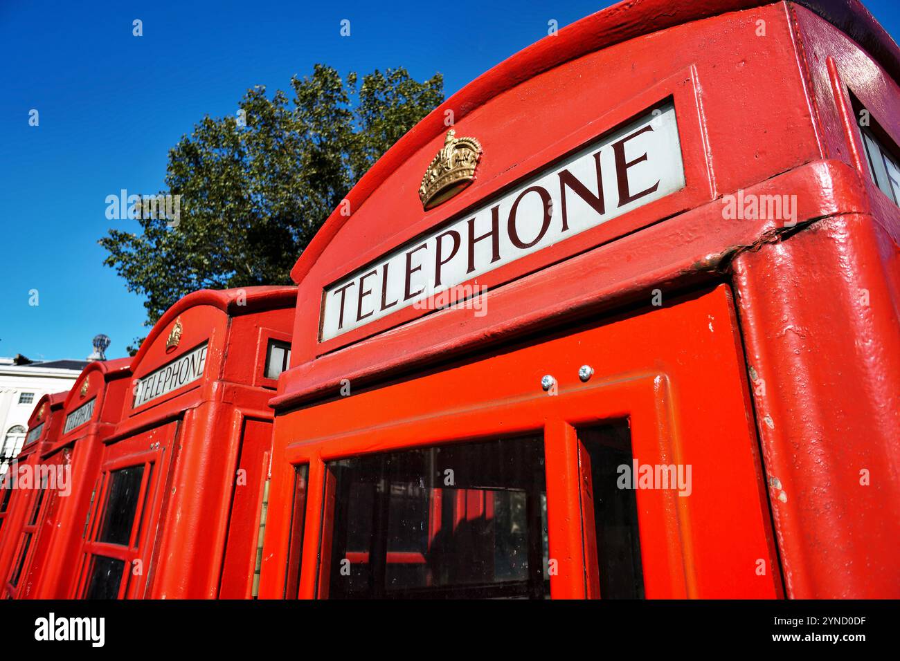 Red Telephone Box Londra Regno Unito // LONDRA, Regno Unito — Un classico telefono rosso si trova su una strada di Londra, un simbolo iconico del patrimonio britannico e del design urbano. Progettati da Sir Giles Gilbert Scott negli anni '1920, questi distintivi chioschi K6 con il loro colore rosso brillante e l'insegna della corona divennero sinonimo di paesaggi urbani britannici per tutto il XX secolo. Anche se ampiamente obsoleto nell'era della telefonia mobile, molti di questi storici stand sono stati conservati come punti di riferimento protetti o riutilizzati per usi alternativi in tutto il Regno Unito. Foto Stock