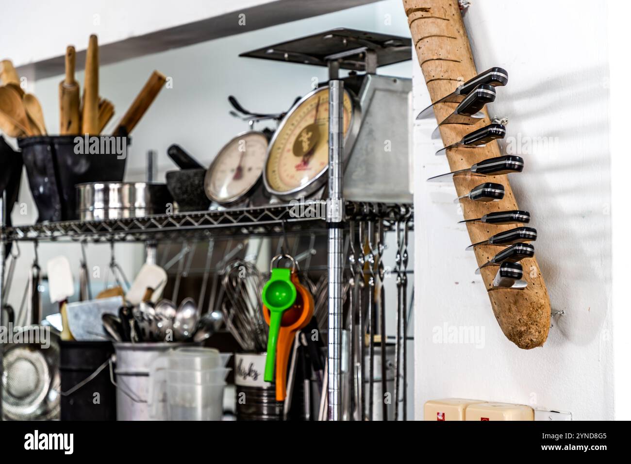 Utensili da cucina nella scuola di cucina dello chef e avvocato Helmi Smeulders su Djonora Marthaweg, Willemstad, Curaçao: cucchiai di legno, setacci, cucchiai da misura e un portacoltelli realizzato con un unico pezzo di legno alla deriva, montato sulla parete. Nei suoi laboratori di cucina, Smeulders offre una visione della cucina caraibica e creola di Curaçao. Foto Stock