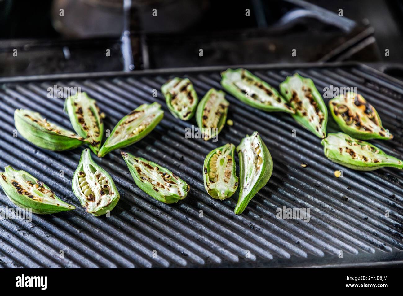 Laboratorio di cucina caraibica con lo chef Helmi Smeulders. L'okra cotto in acqua fa una zuppa melmosa. Hanno anche un buon sapore di tostatura e i semi possono essere utilizzati per arrostire un sostituto del caffè. Djonora Marthaweg, Kòrsou, Curacao, Curacao Foto Stock
