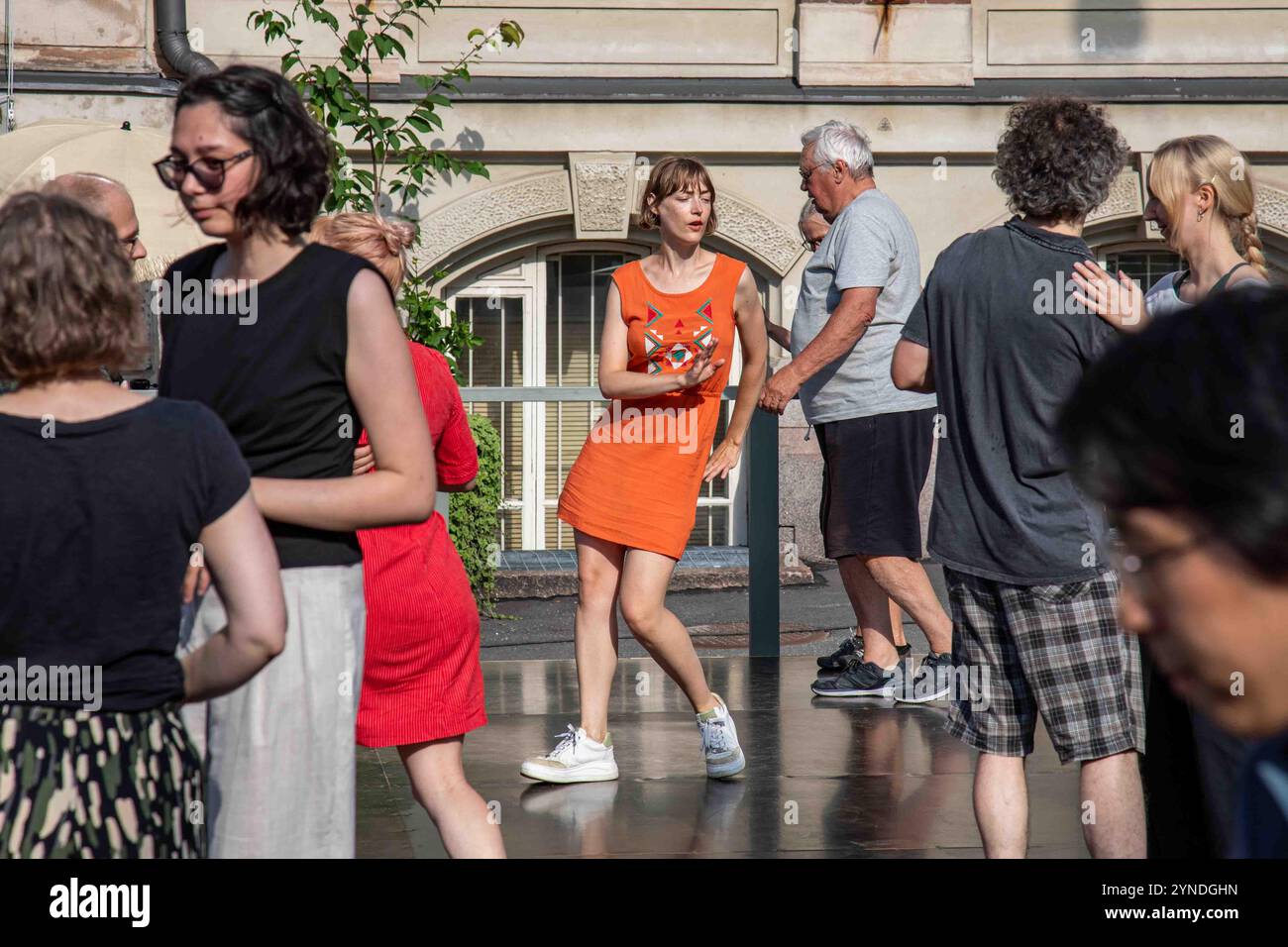 Donna in abito arancione che balla al Rock'n'Swing Dance Club Comets all'aperto nella Piazza del Museo del Design di Helsinki, Finlandia Foto Stock