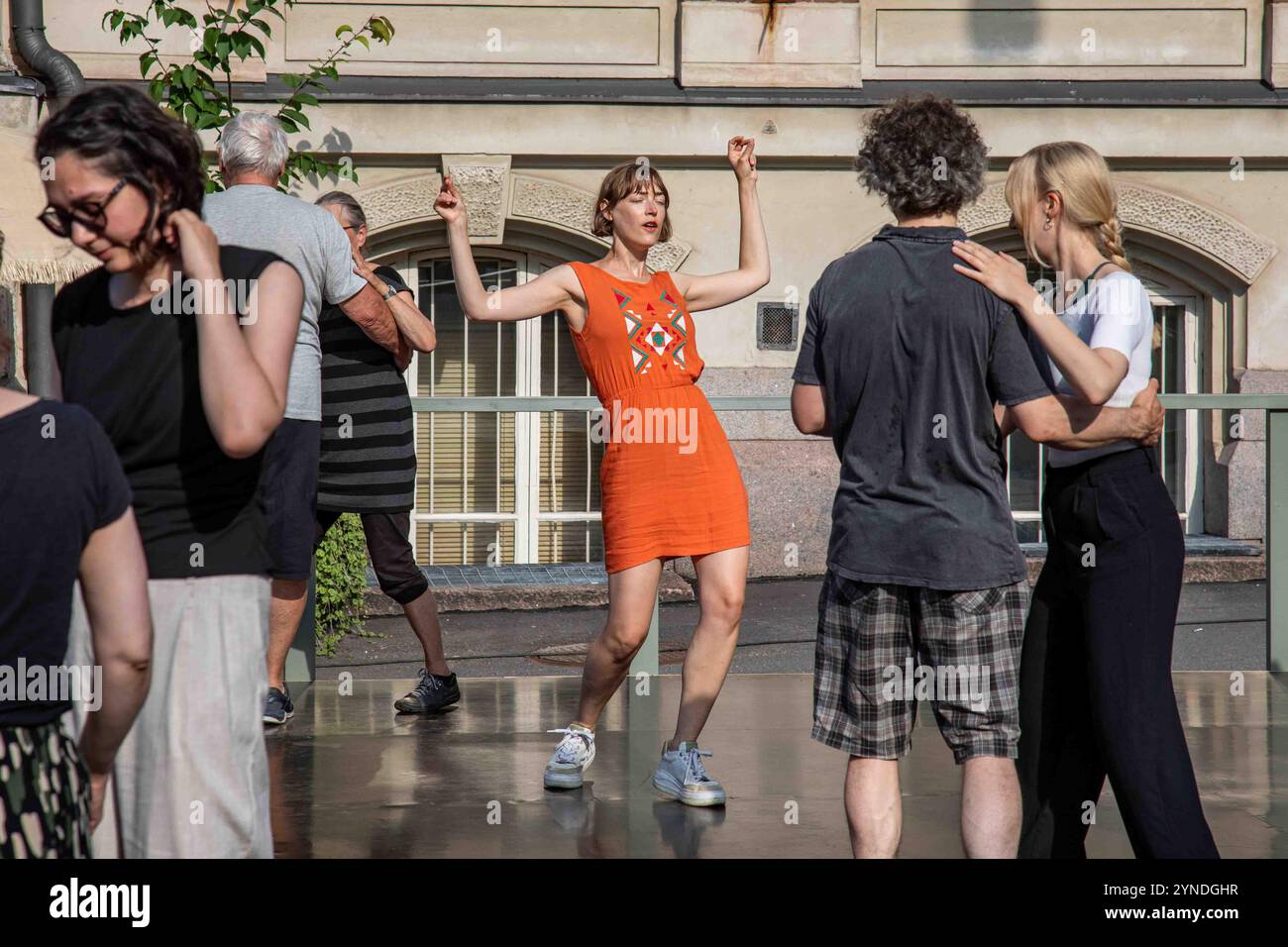 Donna in abito arancione che danza all'evento di danza all'aperto Rock'n'Swing Dance Club Comets nel quartiere Ullanlinna di Helsinki, Finlandia Foto Stock