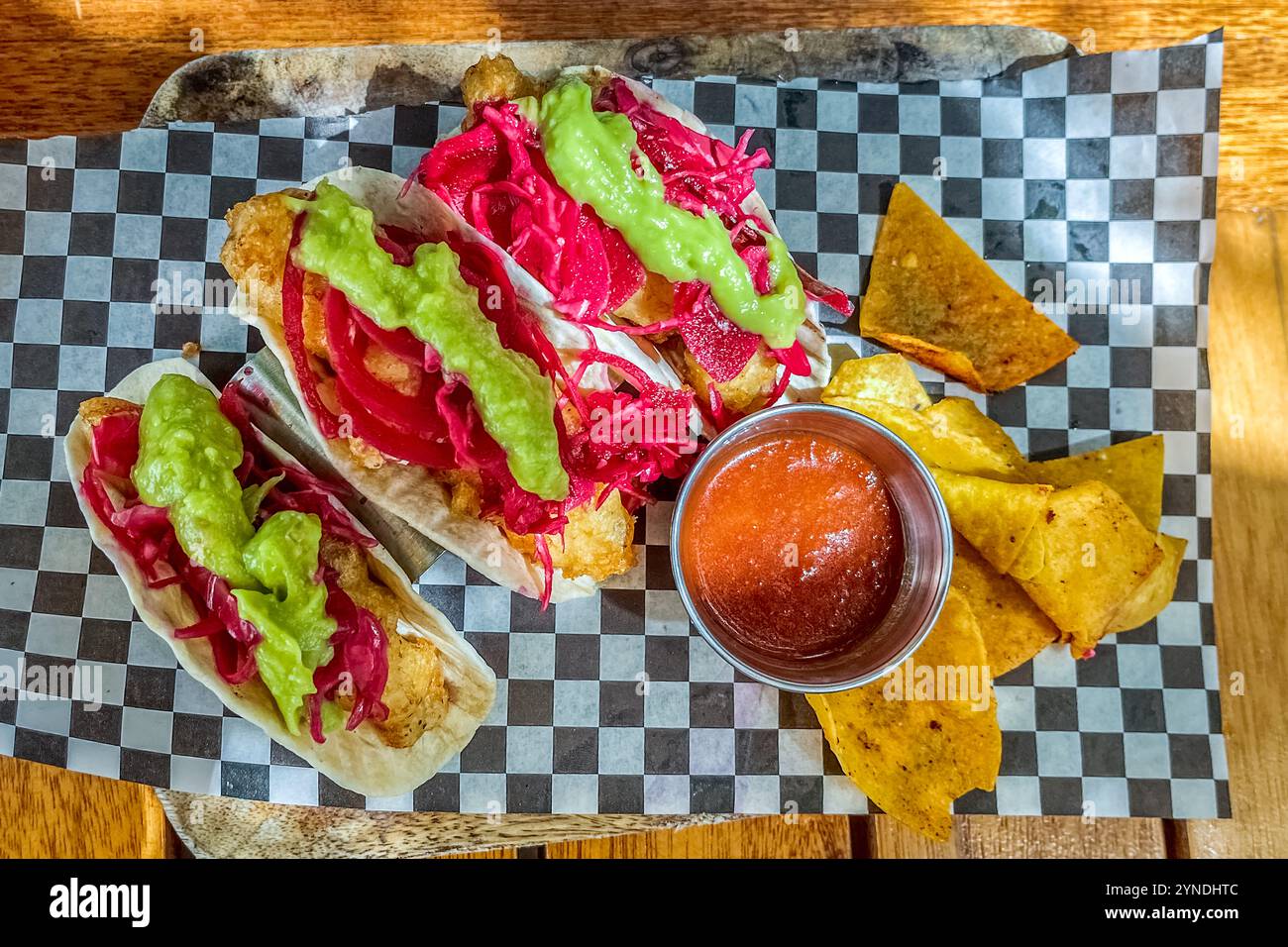 "Drunken Fish Tacos" al ristorante Brisa do Mar su Caracasbaaiweg, Jan Thiel, Curaçao: tre tortillas di frumento con pesce fritto, guacamole, cavolo rosso e pomodori, serviti con chips di tortilla e salsa. Situato nel sud-est dell'isola, Jan Thiel è una destinazione popolare per ristoranti e bar sulla spiaggia. ## Lotto Curaçao 04 (2026-09-08) Foto Stock