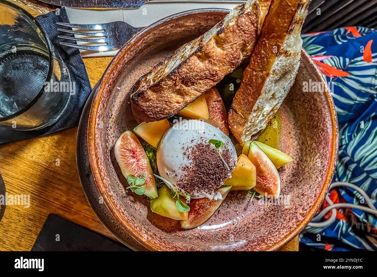 La burrata con melone cantalupo, fichi, prosciutto, aceto balsamico e focaccia tostata è servita al MosaCaña Bar & Kitchen, Penstraat 41, Willemstad, Curaçao. Il ristorante di Penstraat serve una cucina fusion mediterranea-caribica. Il suo bar offre solo rum, tequila e mezcal. Foto Stock