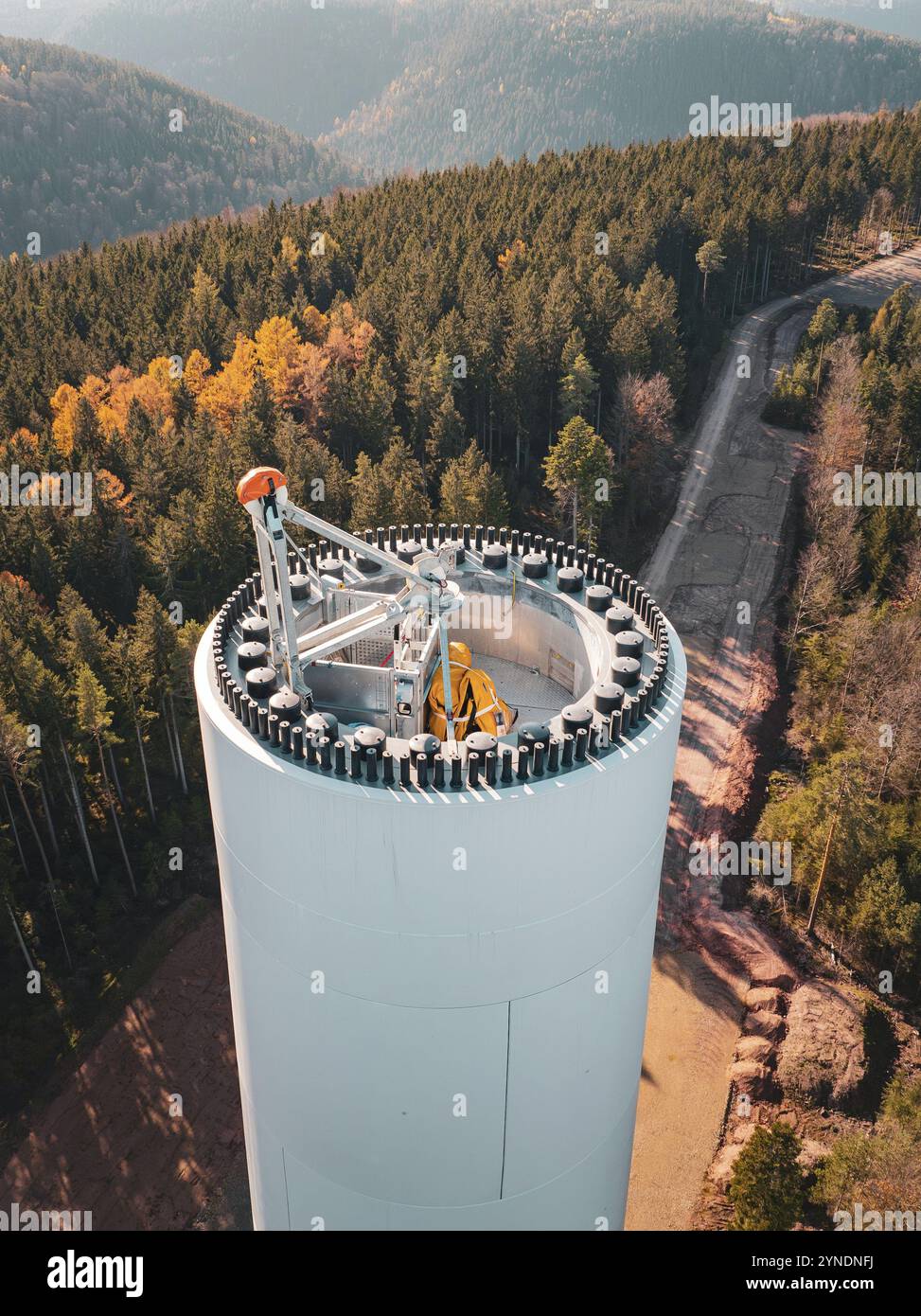 Paesaggio autunnale con una turbina eolica in costruzione, circondato da foreste colorate e terreni montuosi, costruzione di turbine eoliche, Calmbach, Foto Stock