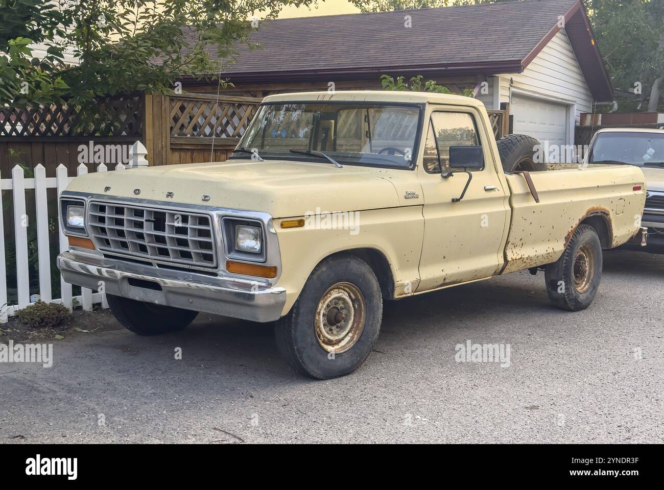 Calgary, Alberta, Canada. 21 luglio 2024. Un'assolata scena suburbana con un pick-up giallo Un modello Ford F-Series Ranger parcheggiato nel vialetto di una nea Foto Stock