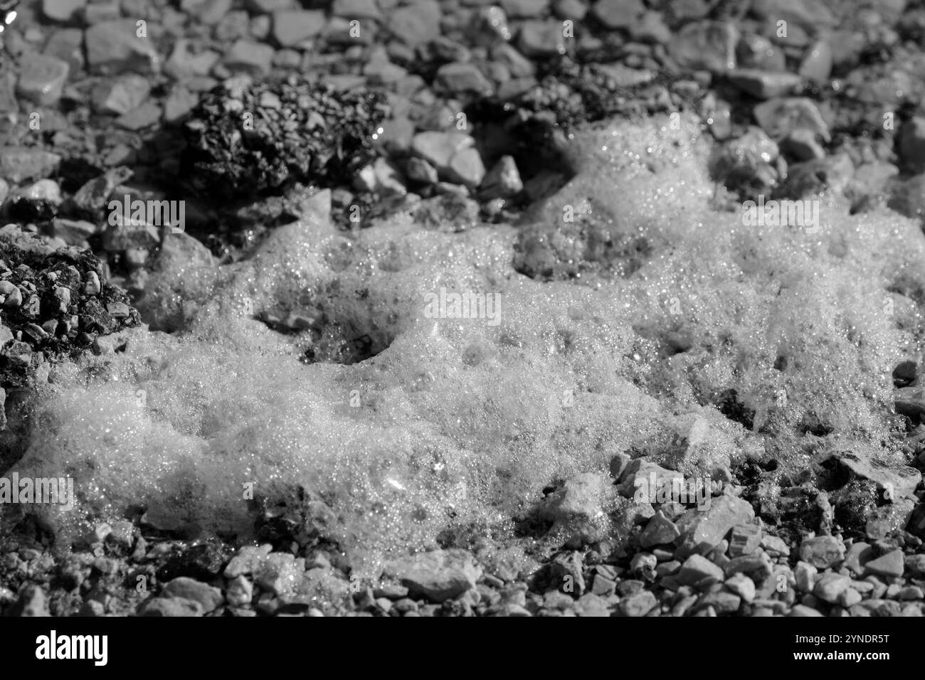 Spiaggia in riva al mare con spruzzi di schiuma dalle onde Foto Stock