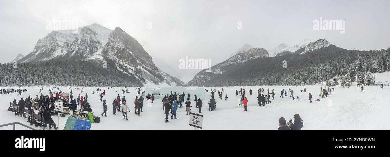 Lago Louise, Alberta, Canada. 29 gennaio 2024. Una scena panoramica che cattura gli individui impegnati nel pattinaggio sul ghiaccio sulla distesa ghiacciata del lago Louise, incorniciano Foto Stock