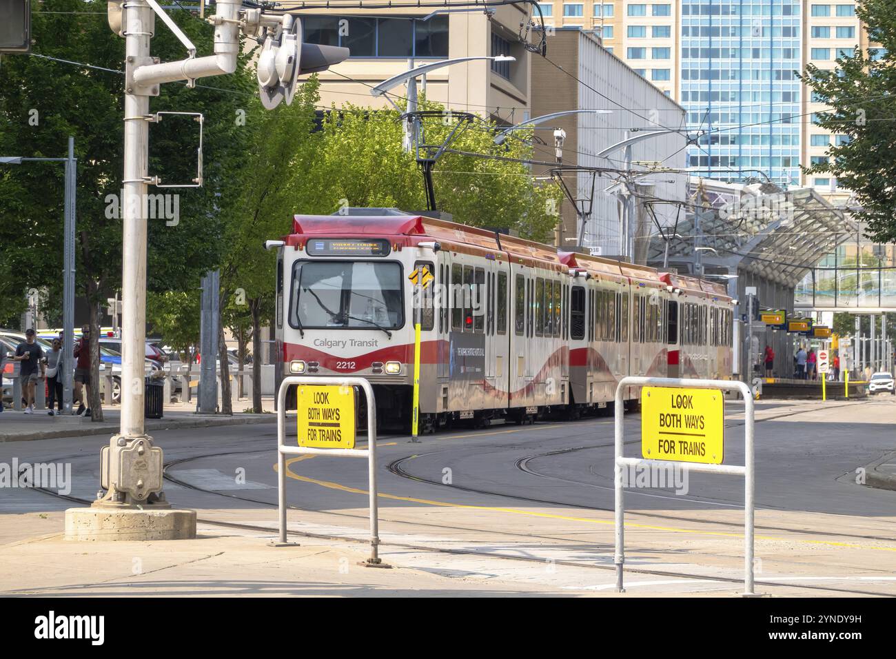 Calgary, Alberta, Canada. 5 agosto 2024. Un Calgary Transit CTrain rosso e bianco naviga in un incrocio cittadino, con prominente Foto Stock