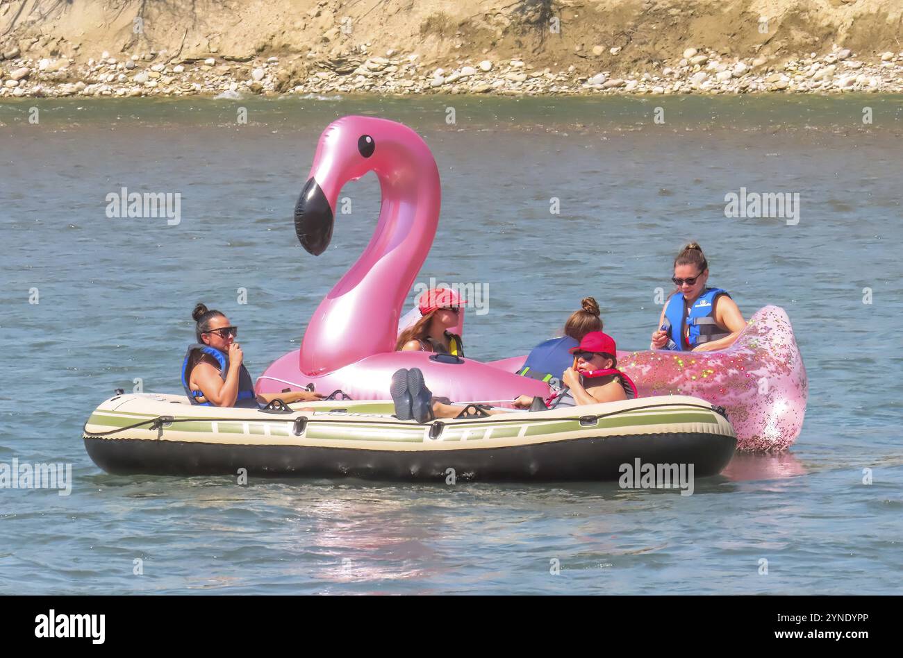Calgary, Alberta, Canada. 22 luglio 2023. Alcune persone su un fenicottero rosa gigante gonfiabile, che galleggia sul fiume Bow durante l'estate. Concetto: Zattera Foto Stock