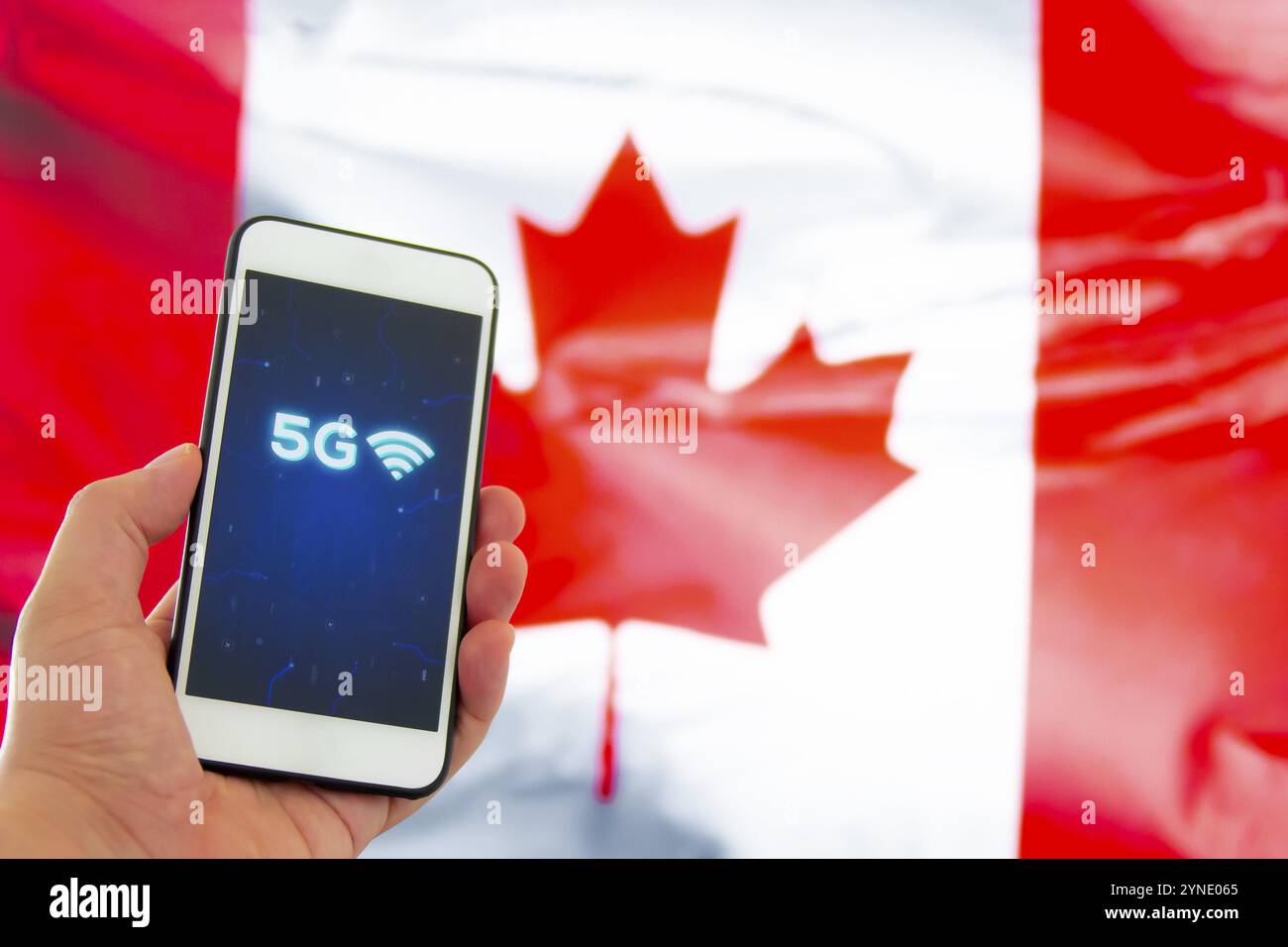 Una persona che tiene uno smartphone con un cartello 5G su sfondo bandiera canadese Foto Stock