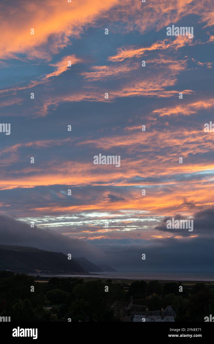 Un tramonto basso, piovoso e nuvoloso sulla baia di Porlock con il promontorio di Gore Point che scende verso il mare Foto Stock