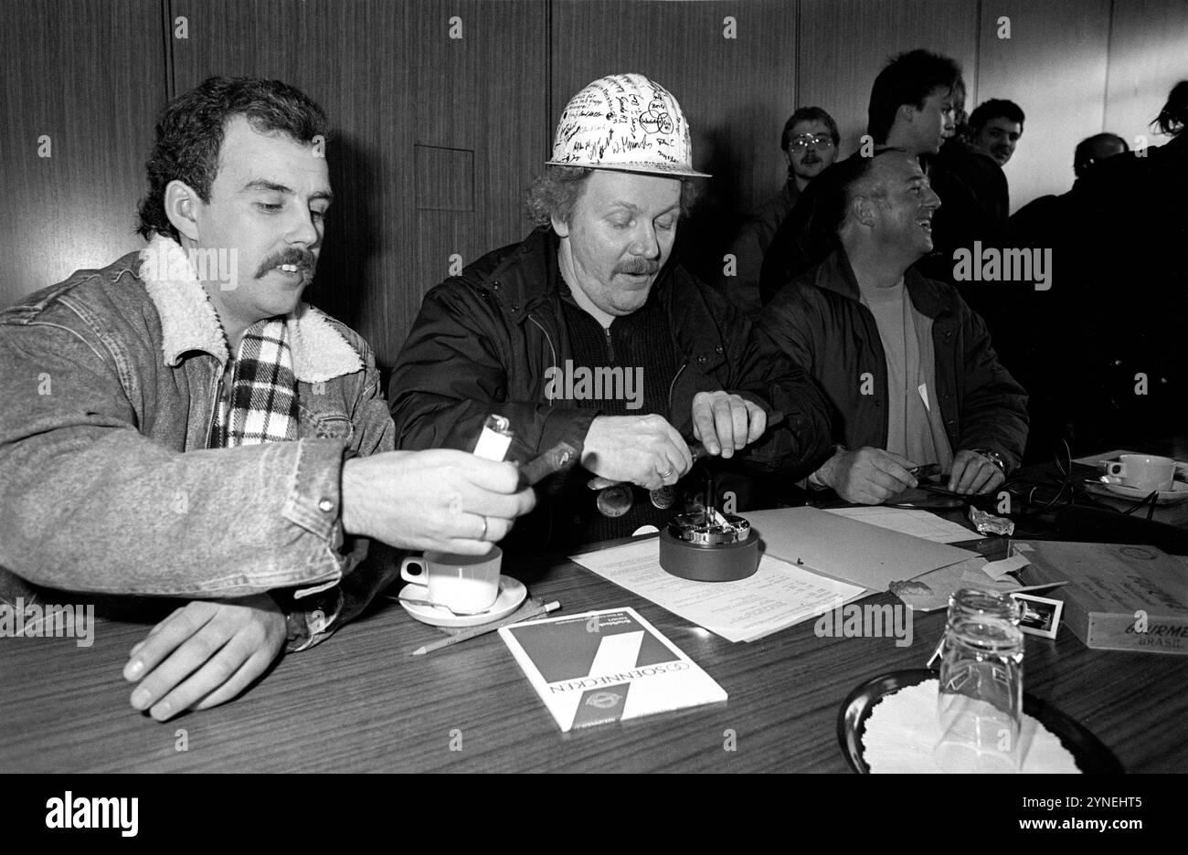 Arbeiter des Stahlwerkes Rheinhausen stürmen am 7.12.1987 das Krupp-Hochhaus in Bochum und besetzen den Raum, in dem eine Aufsichtsratssitzung der Krupp-Stahl AG hätte stattfinden sollen. während ihrer Versammlung werden Zigarren angezündet und geraucht. Arbeitskampf in der Stahlindustrie *** i lavoratori delle acciaierie Rheinhausen assaltano il grattacielo di Krupp a Bochum il 7 dicembre 1987 e occupano la sala in cui avrebbe avuto luogo una riunione del Consiglio di vigilanza di Krupp Stahl AG durante la loro riunione, i sigari sono accesi e fumati disputa sul lavoro nell'industria siderurgica Foto Stock