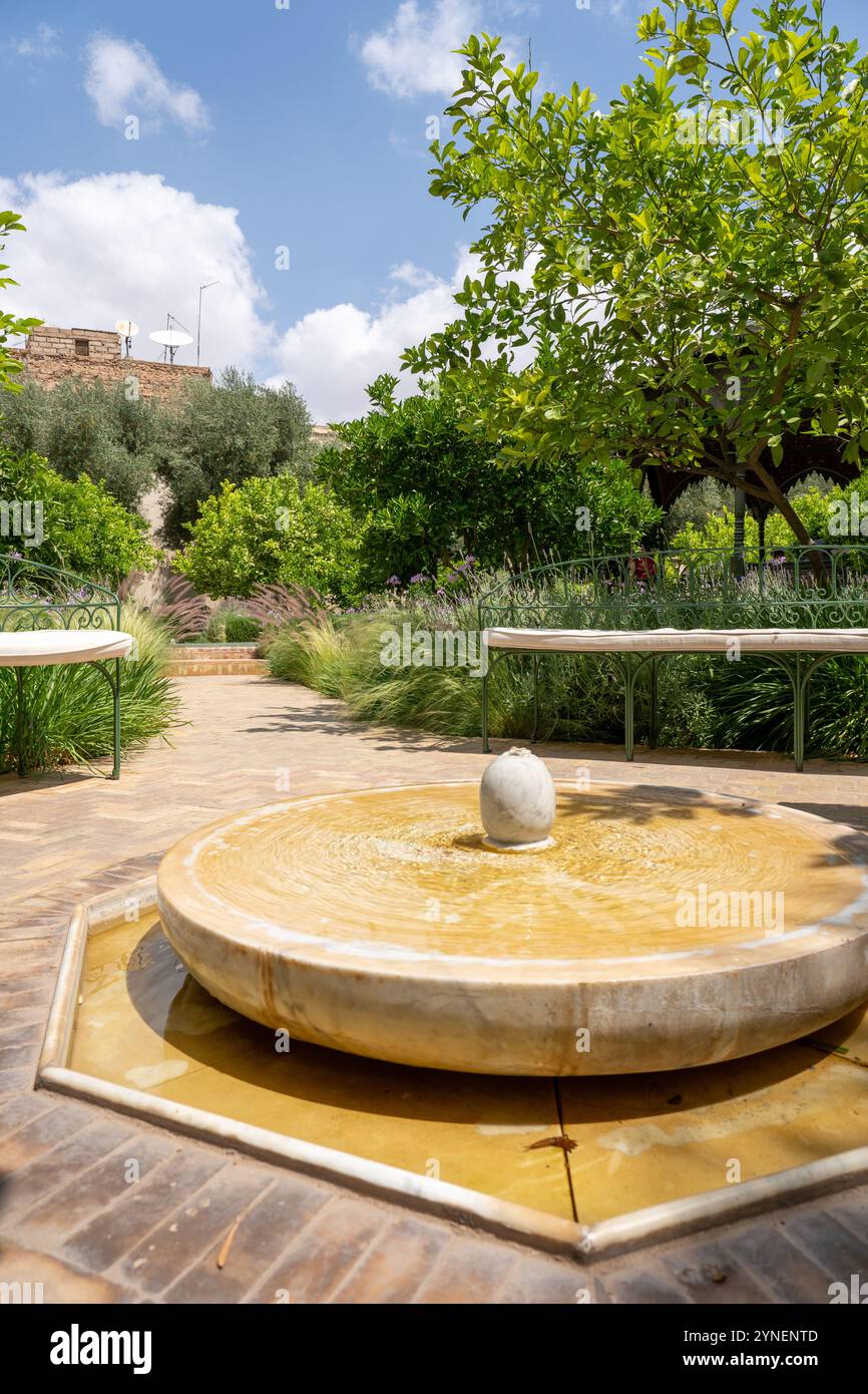 Splendida fontana nel Giardino segreto circondata da vegetazione lussureggiante a Marrakech, Morroco Foto Stock