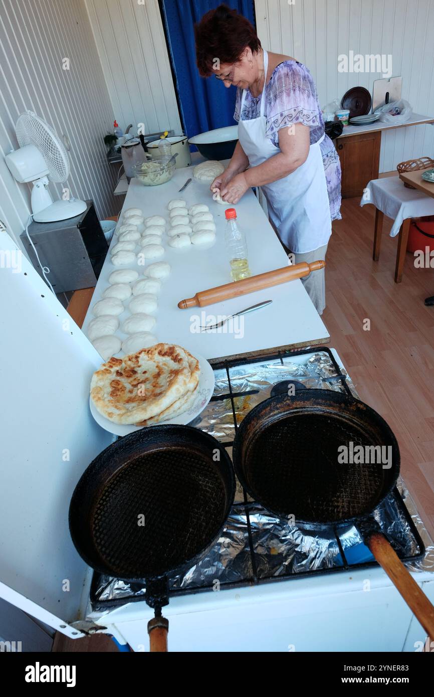 ORADEA, ROMANIA - 01 AGOSTO 2015: Una donna di mezza età in un laboratorio realizzato localmente prepara le palle di impasto per la preparazione della tradizionale placinta Foto Stock