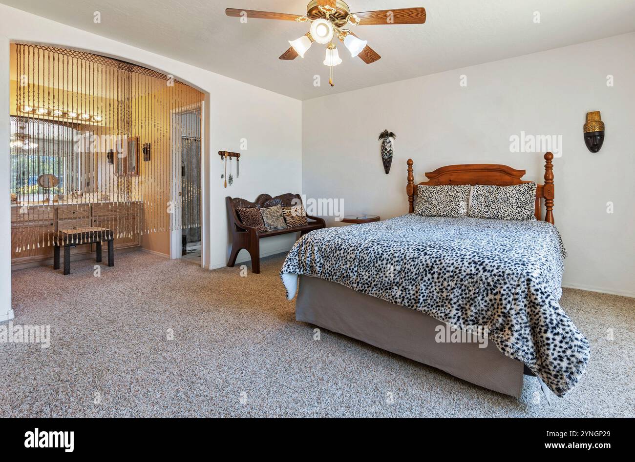 Accogliente camera da letto con luce naturale e arredi incantevoli in un ambiente sereno Foto Stock