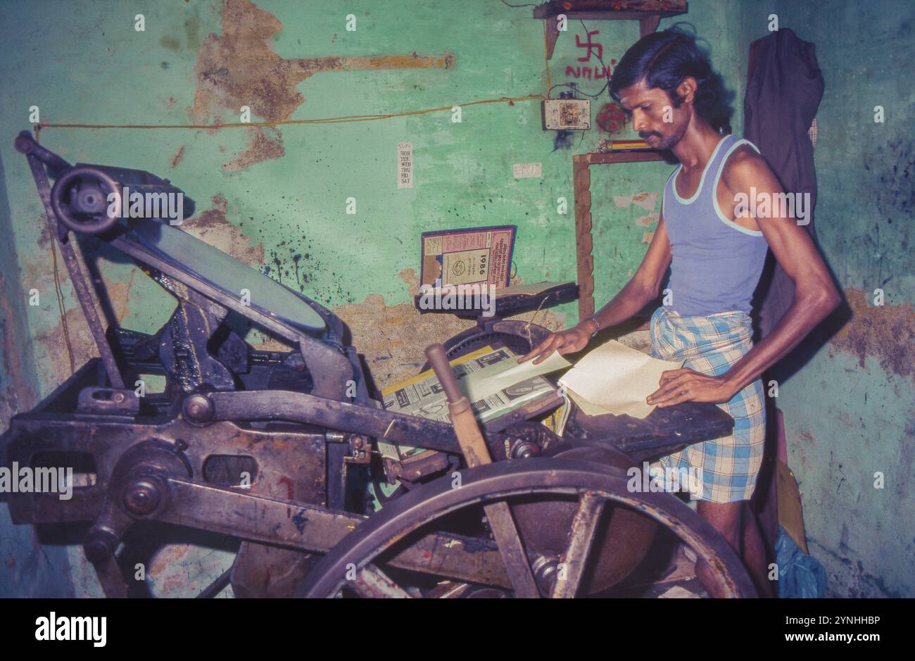 India, Chennai /Madras, una piccola azienda di stampa sta stampando una carta su una vecchia macchina da stampa. Foto Stock