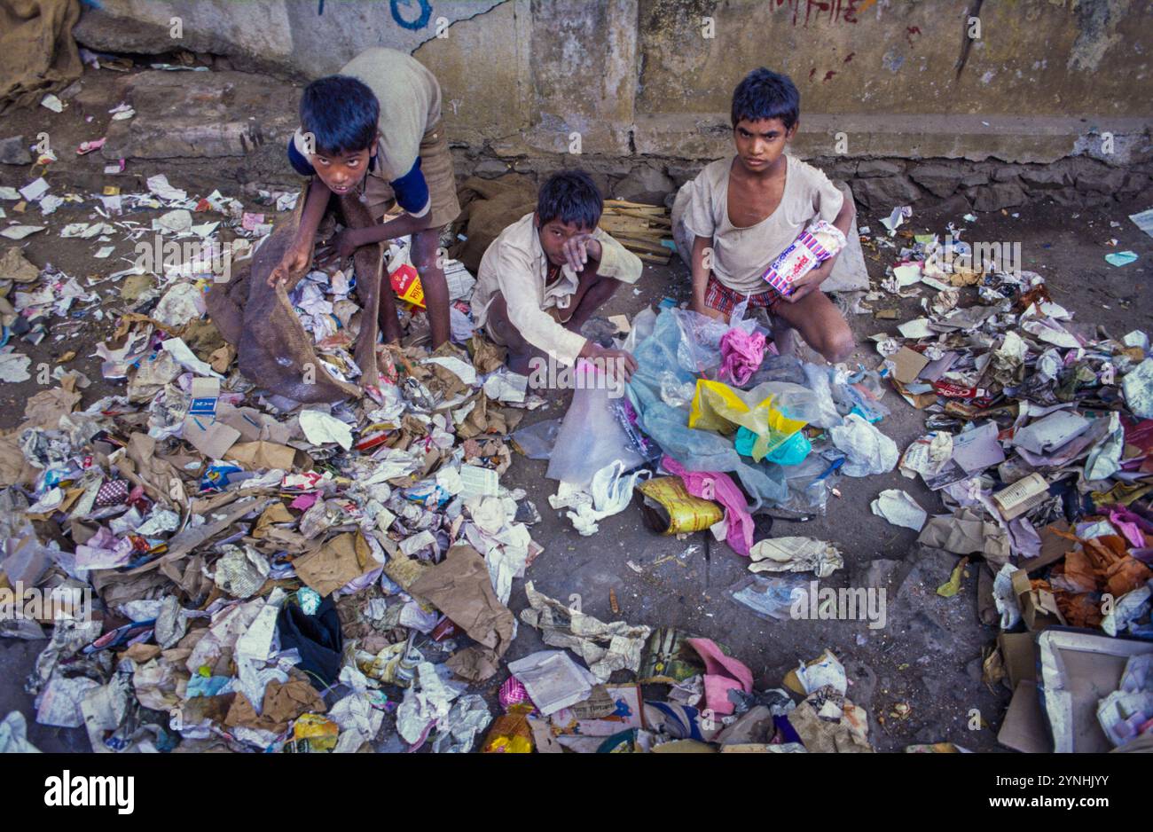 India, Vecchia Delhi, bambini che raccolgono spazzatura per strada. Foto Stock