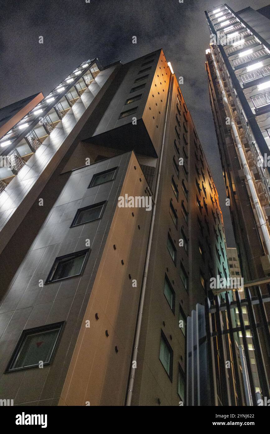 Alti edifici urbani illuminati di notte Foto Stock