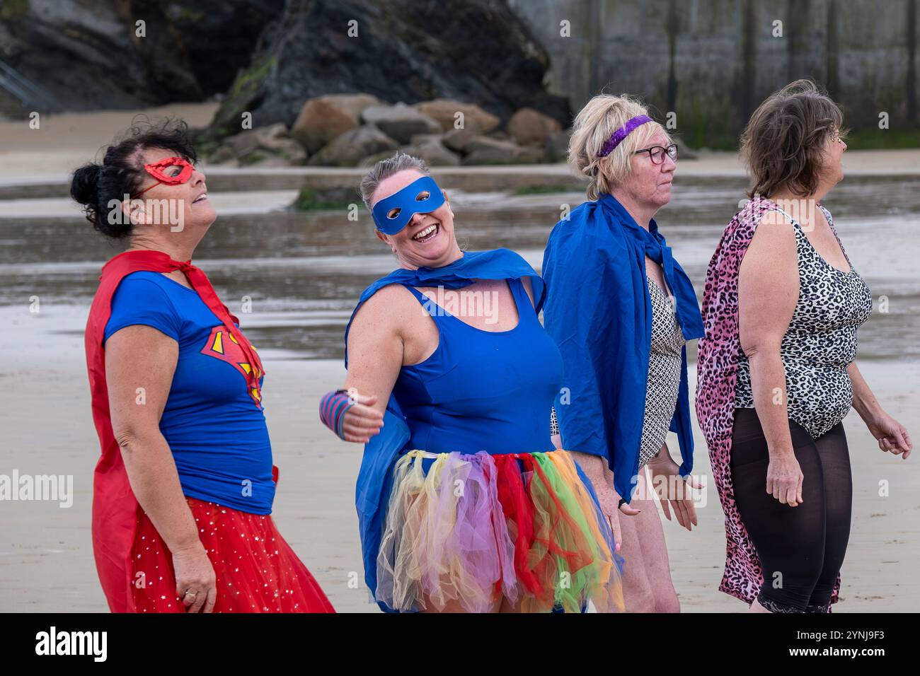 I partecipanti che si riuniscono sulla spiaggia di Towan e si preparano per l’evento annuale “supereroe nel freddo” per raccogliere fondi per la ricerca sul cancro nel Regno Unito. Foto Stock