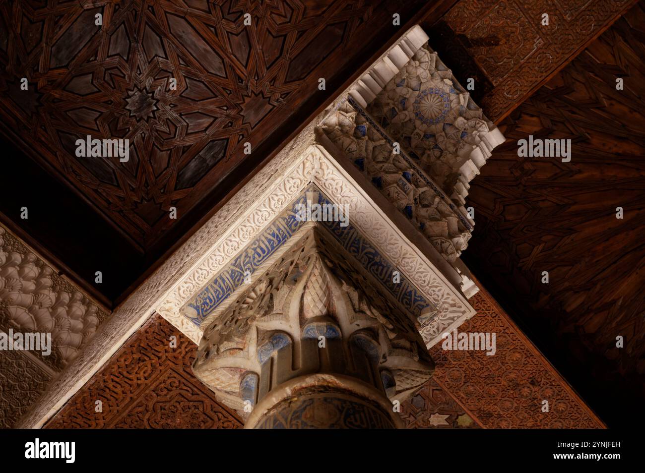 Un'intricata capitale a colonna e dettagli del soffitto all'interno del Palazzo Nasridi dell'Alhambra Foto Stock