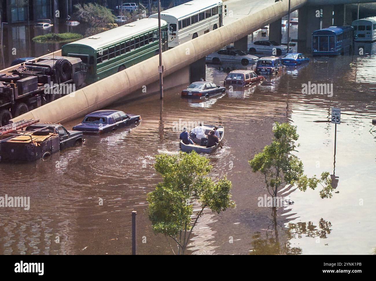 New Orleans, LOUISIANA, Stati Uniti d'America - agosto 2005: Una barca che salva le vittime delle inondazioni passa la rampa del Superdome e parcheggia le auto su Poydras Street allagata e gli autobus di evacuazione allineati sulla rampa del Superdome. Questa foto è stata scattata con una macchina fotografica da 35 mm dopo che l'uragano Katrina è passato e gli argini del corpo degli ingegneri dell'esercito degli Stati Uniti hanno fallito, inondando la maggior parte della città. Foto Stock