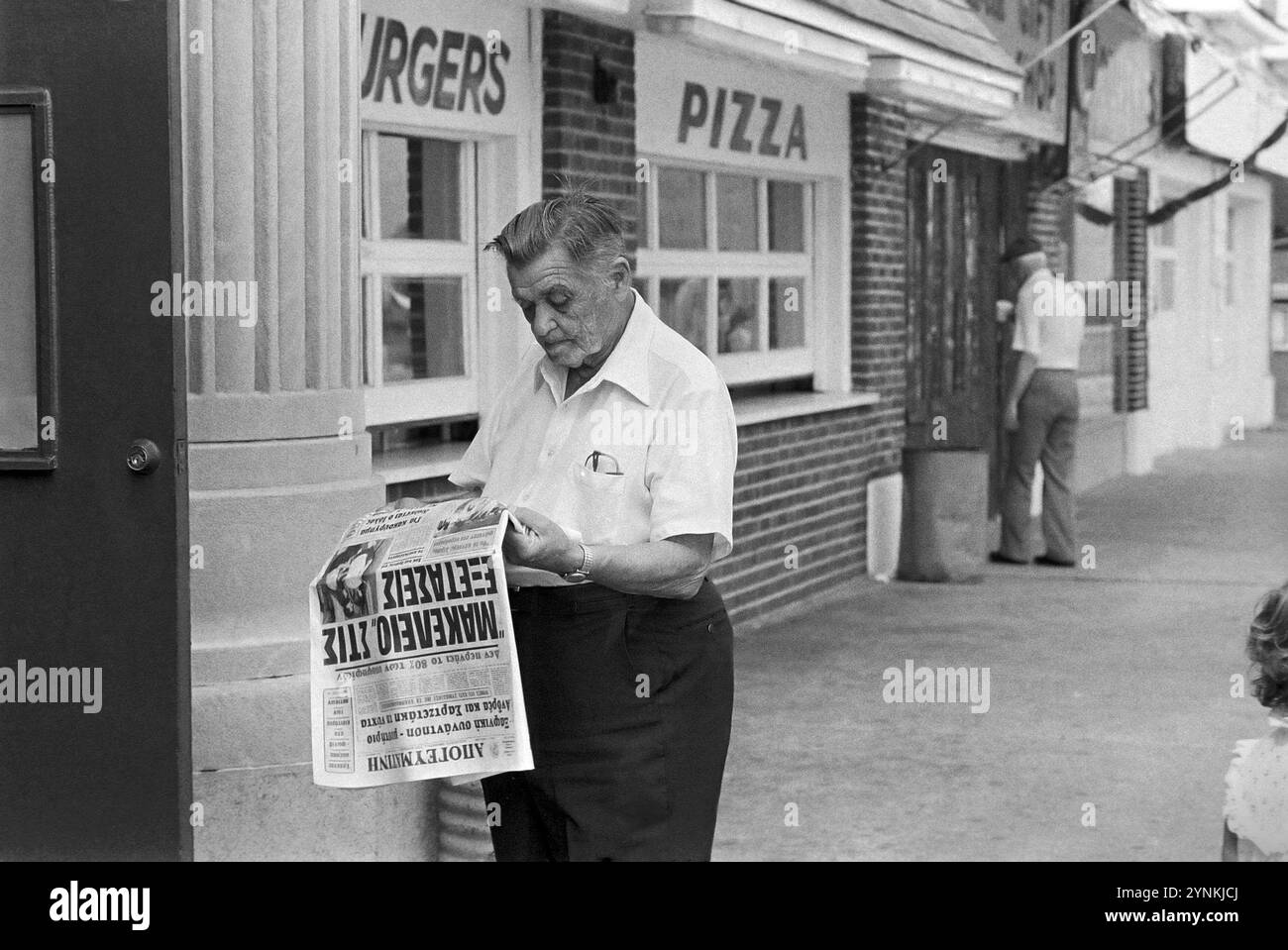 - USA, New Jersey, Asbury Park immigrato greco che legge un giornale (luglio 1985)- USA, New Jersey, Asbury Patrk, immigrato greco legge un giornale (luglio 1985) Foto Stock