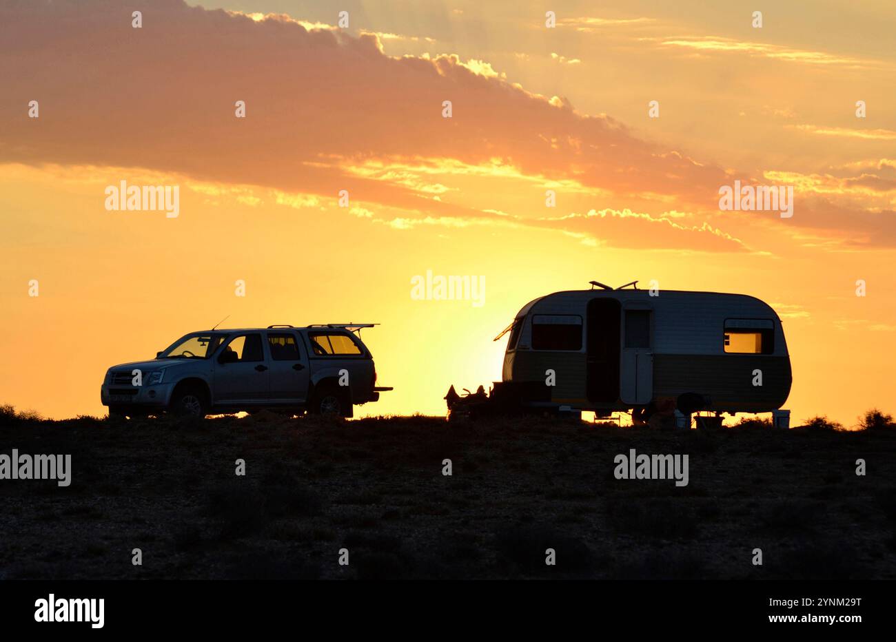 Carovana di allevatori di pecore con fuoco da campo sulla strada di trekking del Knersvlakte, Namaqualand al tramonto. Foto Stock