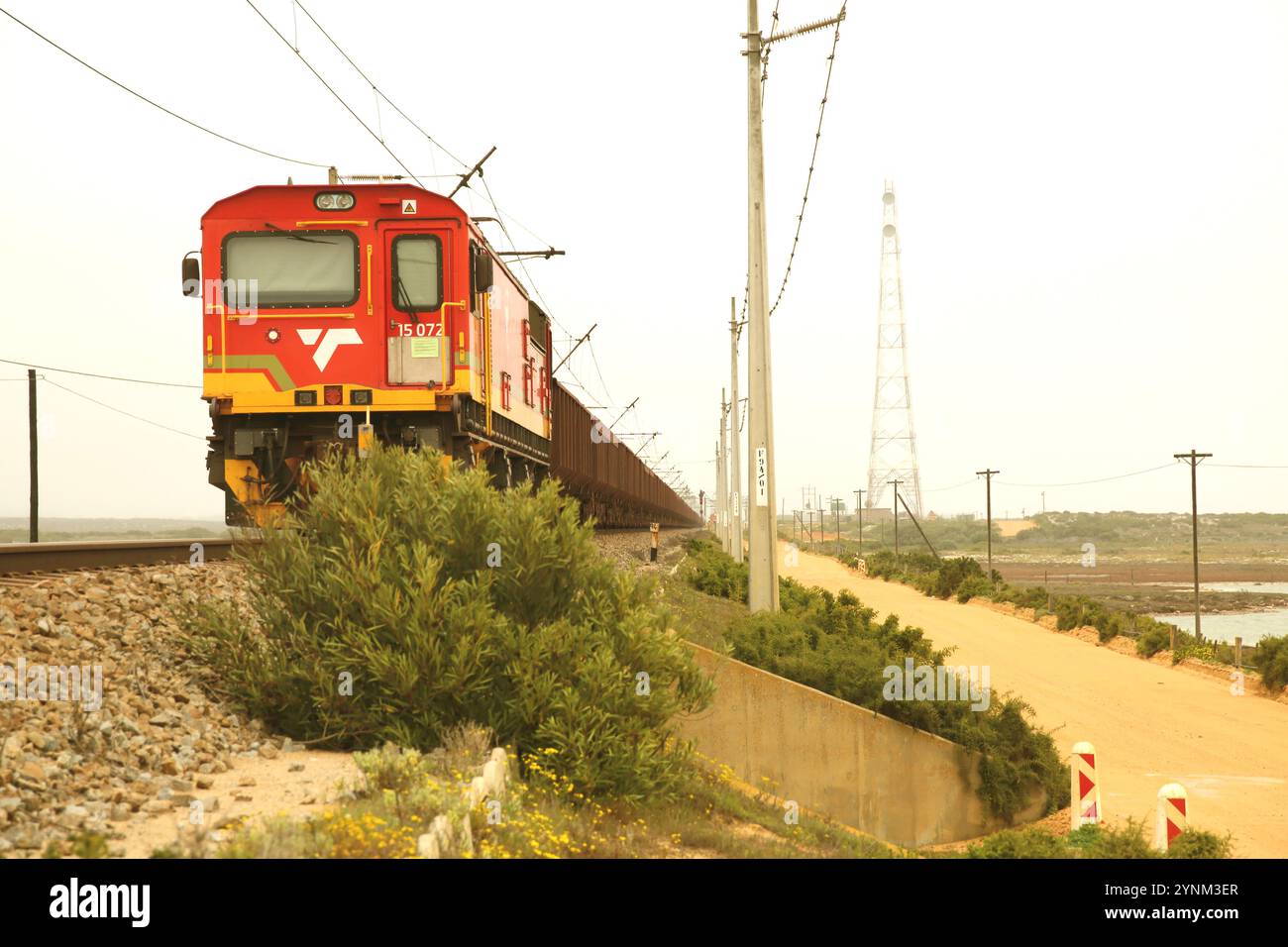 Il treno Sishen-Saldanha con vagoni tramogge di minerali che lasciano Saldanha Bay sulla costa occidentale del Sudafrica. Foto Stock