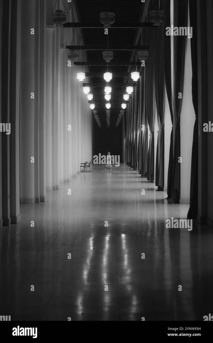 Una donna passeggia attraverso il corridoio della moschea. Foto Stock