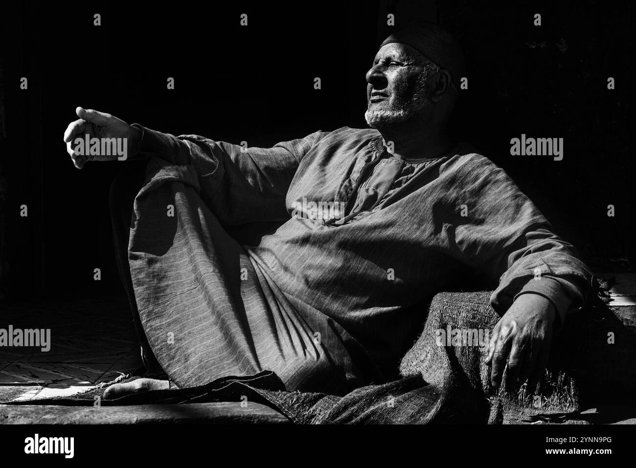 Un uomo seduto di fronte alla sua casa nella campagna egiziana Foto Stock