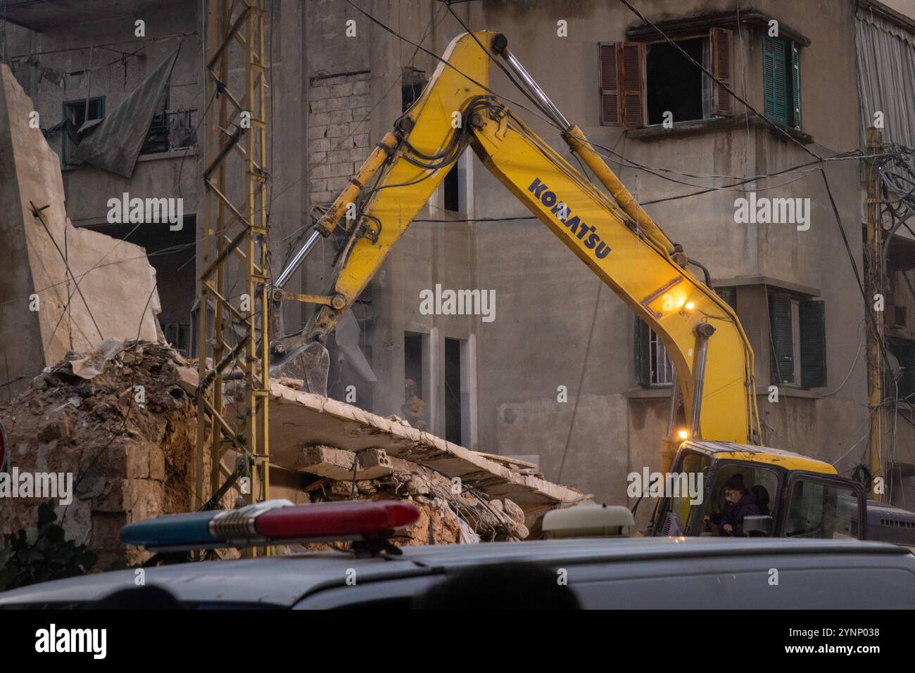 Beirut, Libano. 26 novembre 2024. Una terna lavora per sgombrare un edificio residenziale livellato da un attacco israeliano il 26 novembre 2024 a Beirut, in Libano. Le strade erano caotiche, dato che la gente portava sacchi di evacuazione e cercava le mappe per trovare luoghi sicuri dove fuggire. Sono state sentite sparatorie anche quando la gente ha avvertito i loro vicini quando Israele minacciava luoghi. Le forze israeliane hanno ripetutamente attaccato Beirut e in tutto il Libano prima di un possibile cessate il fuoco. (Credit Image: © Daniel Carde/ZUMA Press Wire) SOLO PER USO EDITORIALE! Non per USO commerciale! Foto Stock