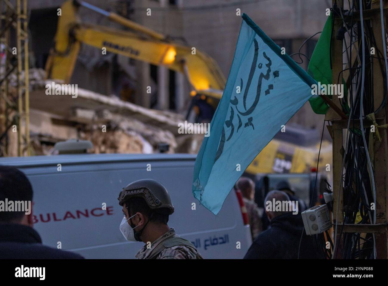 Beirut, Libano. 26 novembre 2024. Un soldato si assicura la posizione mentre una terna lavora per sgomberare un edificio residenziale livellato da un attacco israeliano il 26 novembre 2024 a Beirut, in Libano. Le strade erano caotiche, dato che la gente portava sacchi di evacuazione e cercava le mappe per trovare luoghi sicuri dove fuggire. Sono state sentite sparatorie anche quando la gente ha avvertito i loro vicini quando Israele minacciava luoghi. Le forze israeliane hanno ripetutamente attaccato Beirut e in tutto il Libano prima di un possibile cessate il fuoco. (Credit Image: © Daniel Carde/ZUMA Press Wire) SOLO PER USO EDITORIALE! Non per USO commerciale! Foto Stock