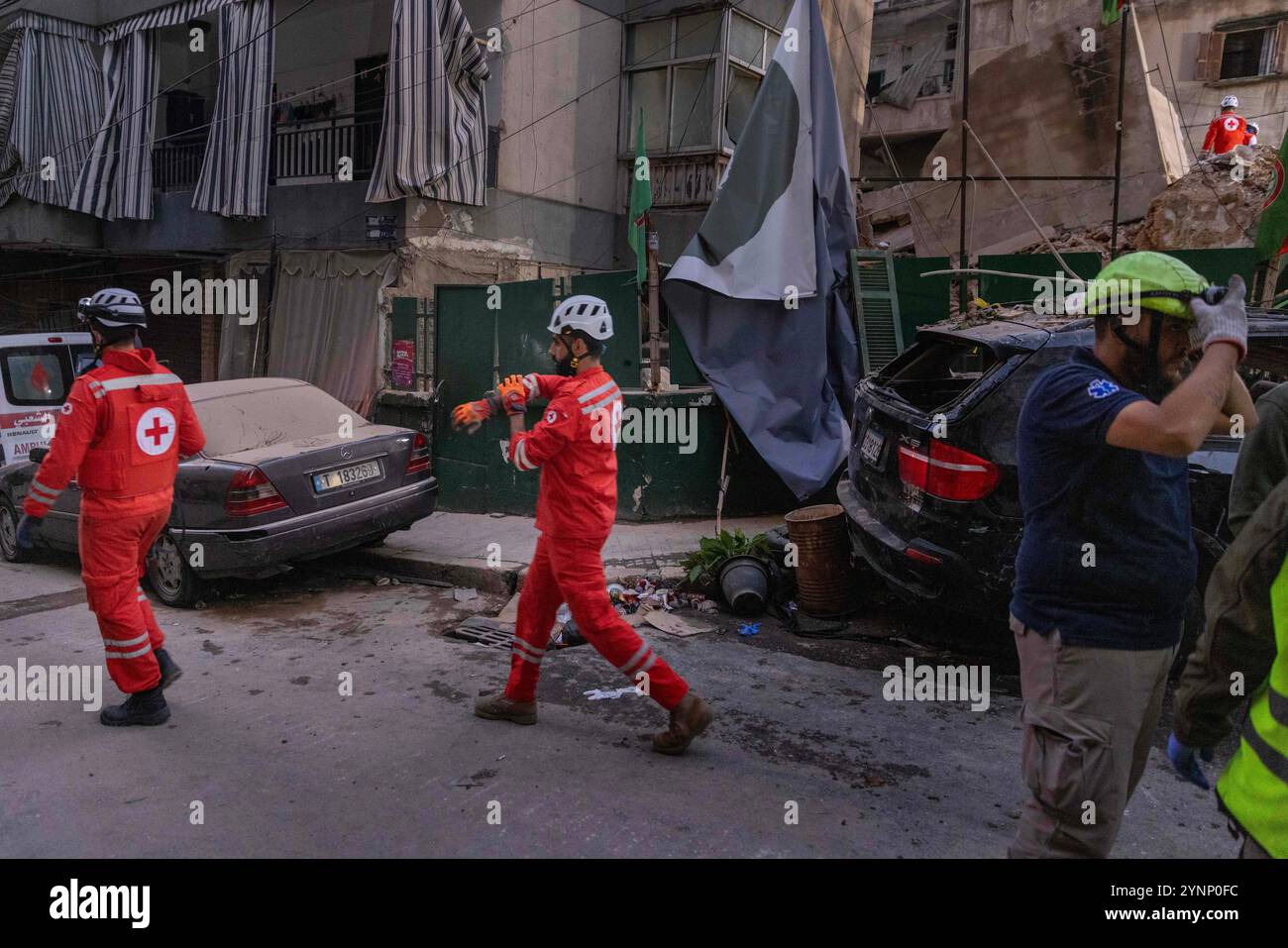 Beirut, Libano. 26 novembre 2024. I primi soccorritori della Croce Rossa libanese camminano vicino a un edificio residenziale livellato da un attacco israeliano il 26 novembre 2024 a Beirut, in Libano. Le strade erano caotiche, dato che la gente portava sacchi di evacuazione e cercava le mappe per trovare luoghi sicuri dove fuggire. Sono state sentite sparatorie anche quando la gente ha avvertito i loro vicini quando Israele minacciava luoghi. Le forze israeliane hanno ripetutamente attaccato Beirut e in tutto il Libano prima di un possibile cessate il fuoco. (Credit Image: © Daniel Carde/ZUMA Press Wire) SOLO PER USO EDITORIALE! Non per USO commerciale! Foto Stock