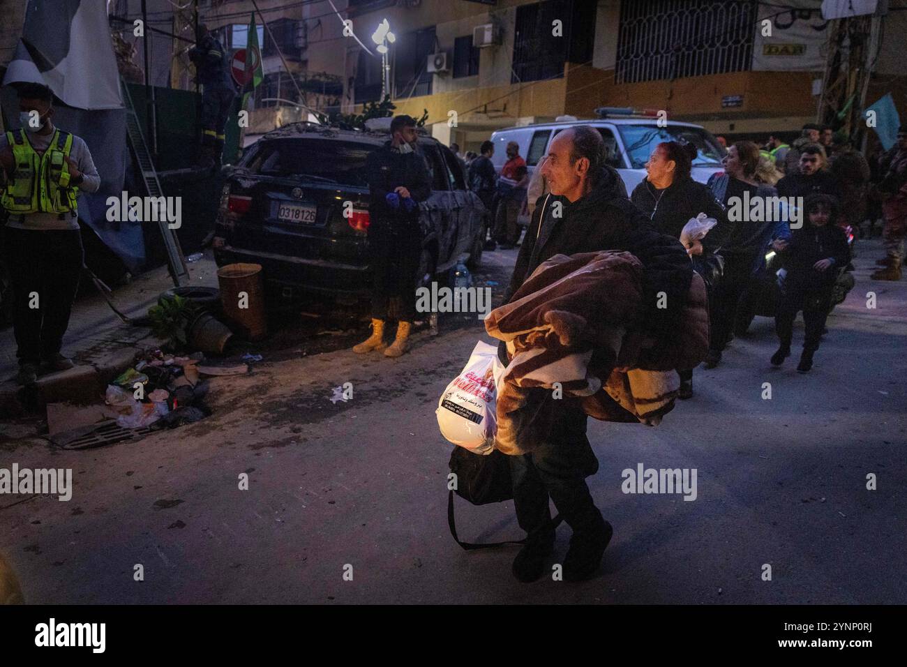 Beirut, Libano. 26 novembre 2024. Persone che trasportano oggetti personali evacuano l'area dopo un attacco israeliano che ha livellato un edificio residenziale il 26 novembre 2024 a Beirut, in Libano. Le strade erano caotiche, dato che la gente portava sacchi di evacuazione e cercava le mappe per trovare luoghi sicuri dove fuggire. Sono state sentite sparatorie anche quando la gente ha avvertito i loro vicini quando Israele minacciava luoghi. Le forze israeliane hanno ripetutamente attaccato Beirut e in tutto il Libano prima di un possibile cessate il fuoco. (Credit Image: © Daniel Carde/ZUMA Press Wire) SOLO PER USO EDITORIALE! Non per USO commerciale! Foto Stock