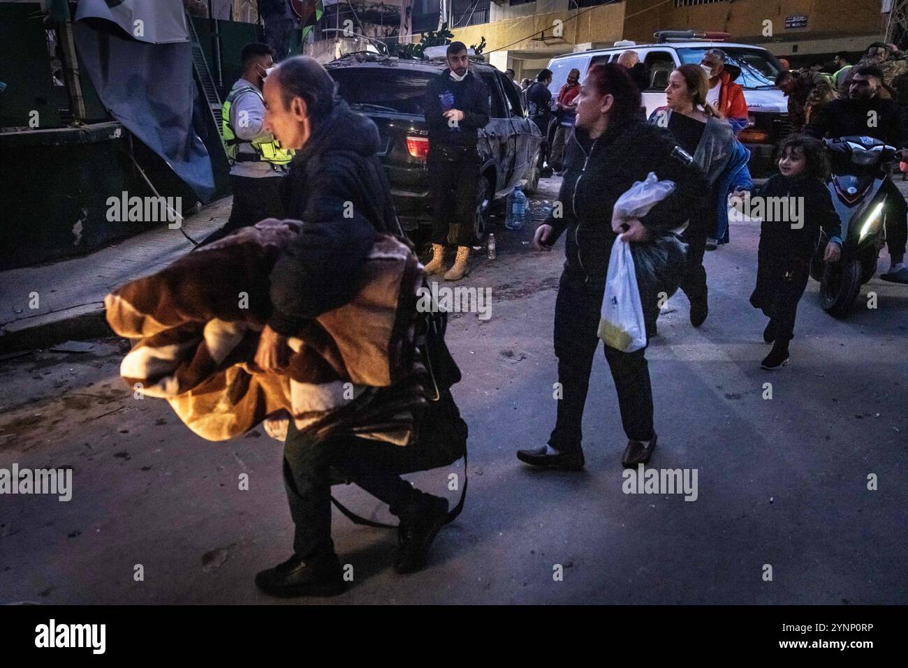 Beirut, Libano. 26 novembre 2024. Persone che trasportano oggetti personali evacuano l'area dopo un attacco israeliano che ha livellato un edificio residenziale il 26 novembre 2024 a Beirut, in Libano. Le strade erano caotiche, dato che la gente portava sacchi di evacuazione e cercava le mappe per trovare luoghi sicuri dove fuggire. Sono state sentite sparatorie anche quando la gente ha avvertito i loro vicini quando Israele minacciava luoghi. Le forze israeliane hanno ripetutamente attaccato Beirut e in tutto il Libano prima di un possibile cessate il fuoco. (Credit Image: © Daniel Carde/ZUMA Press Wire) SOLO PER USO EDITORIALE! Non per USO commerciale! Foto Stock
