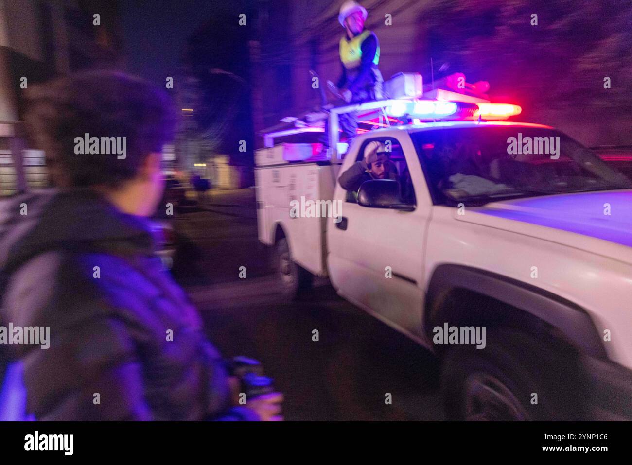 Beirut, Libano. 26 novembre 2024. I lavoratori della difesa civile lasciano il luogo in cui un attacco israeliano ha livellato un edificio residenziale e si spostano verso un nuovo attacco israeliano il 26 novembre 2024 a Beirut, in Libano. Le strade erano caotiche, dato che la gente portava sacchi di evacuazione e cercava le mappe per trovare luoghi sicuri dove fuggire. Sono state sentite sparatorie anche quando la gente ha avvertito i loro vicini quando Israele minacciava luoghi. Le forze israeliane hanno ripetutamente attaccato Beirut e in tutto il Libano prima di un possibile cessate il fuoco. (Credit Image: © Daniel Carde/ZUMA Press Wire) SOLO PER USO EDITORIALE! Non per USO commerciale! Foto Stock