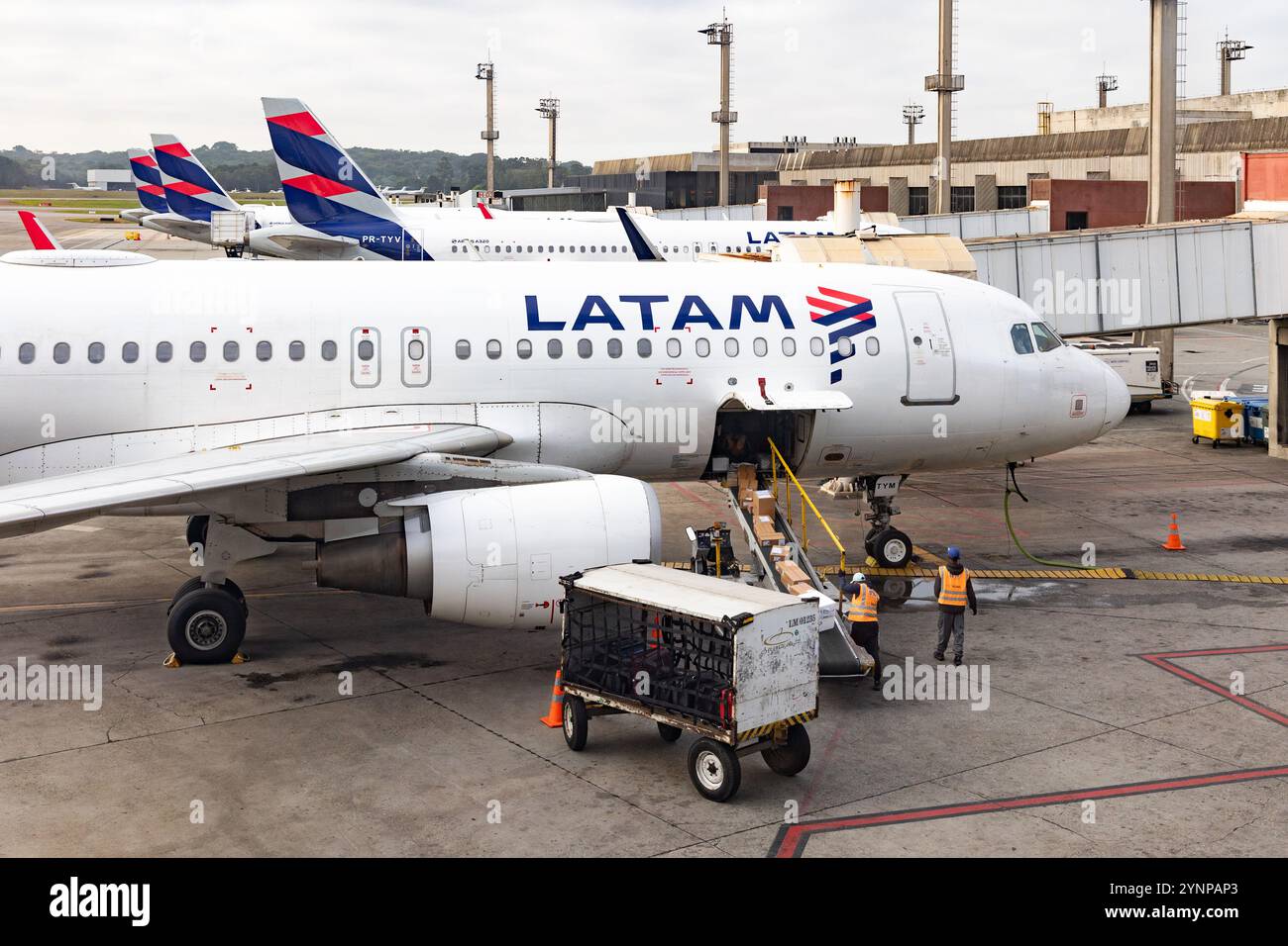 Addetti al trasporto bagagli che caricano un aereo delle compagnie aeree LATAM all'aeroporto di San Paolo, LATAM è la più grande compagnia aerea sudamericana. San Paolo Brasile, Sud America. Foto Stock