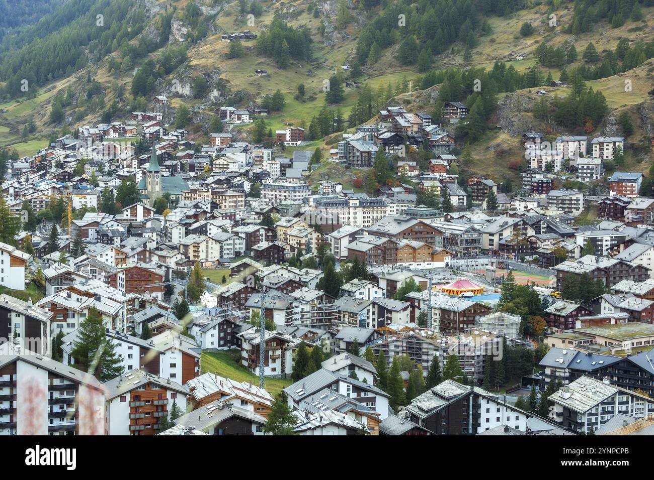 Zermatt, Svizzera, 7 ottobre 2019: Vista aerea della città con chiesa nella famosa stazione sciistica svizzera, case tradizionali colorate, montagne delle Alpi svizzere, EUR Foto Stock