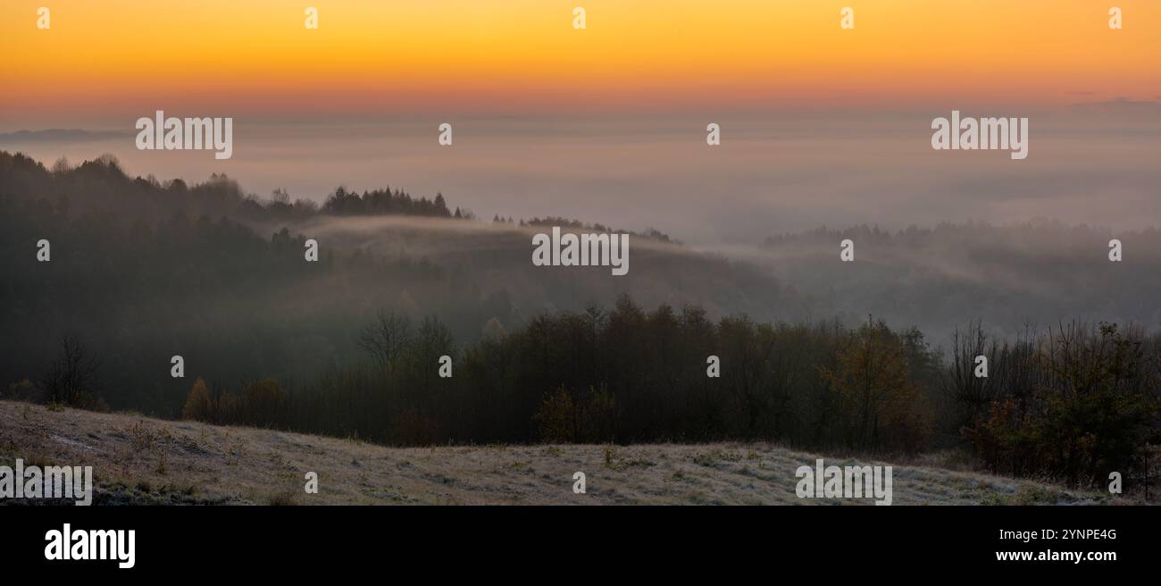 Il sole gelido e nebbioso sorge sulle montagne autunnali della Polonia meridionale Foto Stock