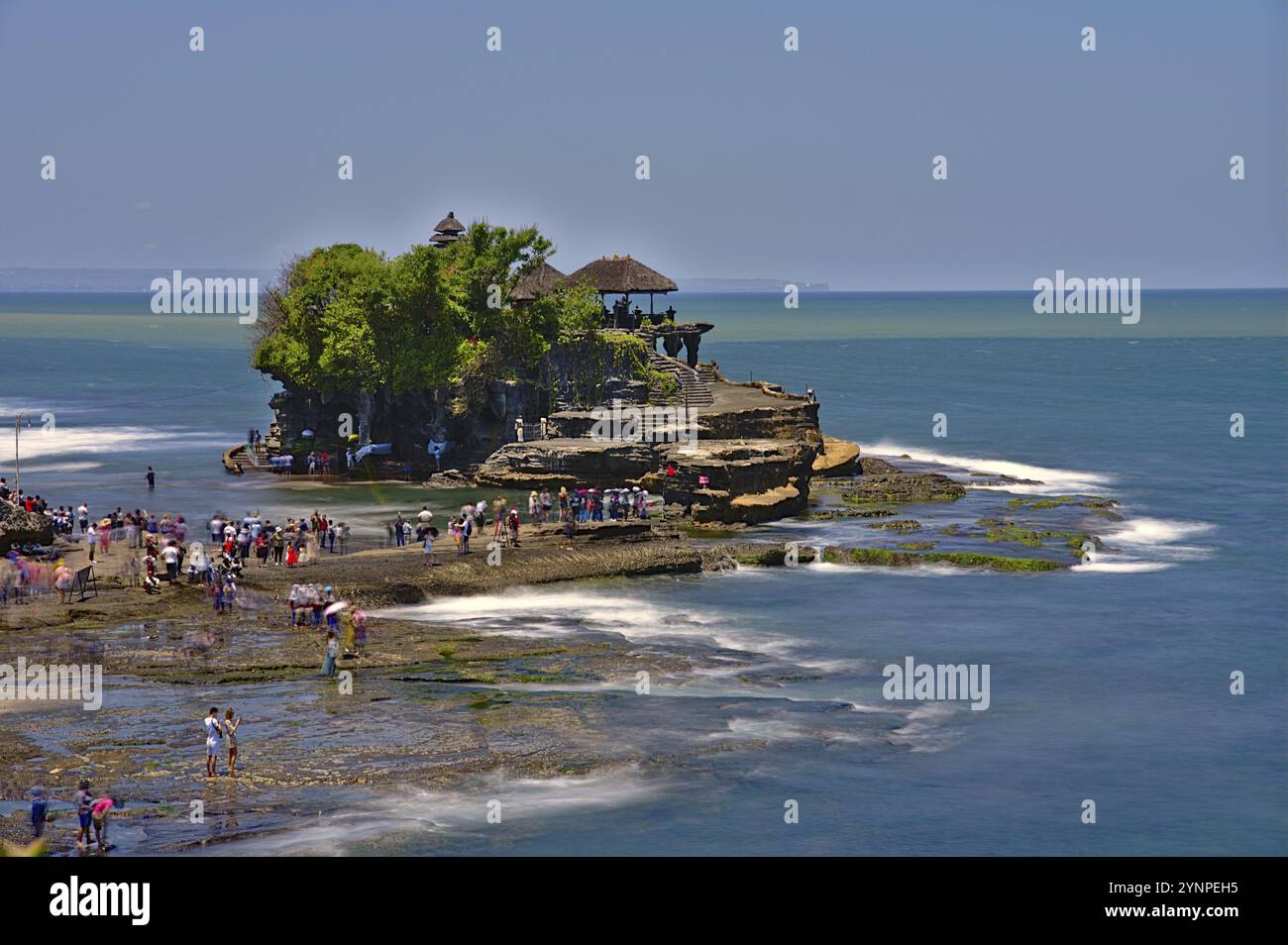 Tempio pura Tanah Lot a Bali di giorno con i turisti. Esposizione lunga con filtro ND Foto Stock